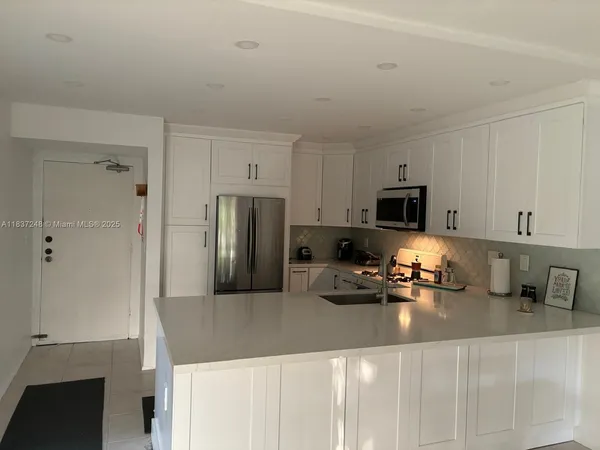 a kitchen with stainless steel appliances a refrigerator a stove a microwave and cabinets