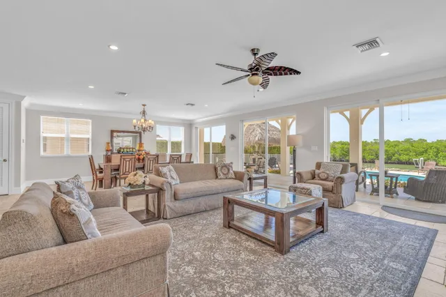 a living room with furniture kitchen view and a chandelier
