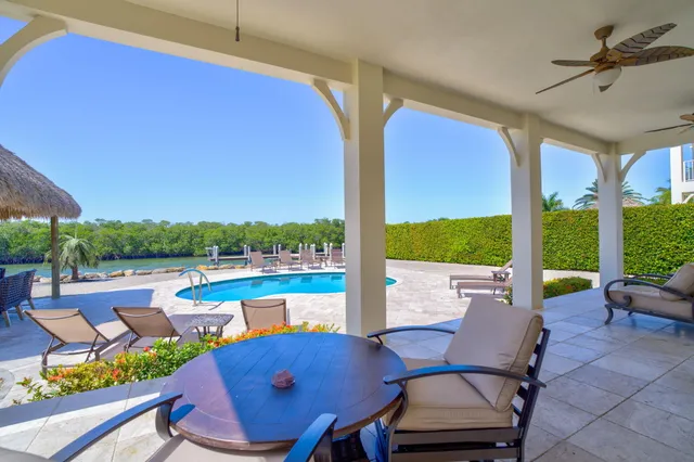 a view of a patio with lawn chairs next to a yard