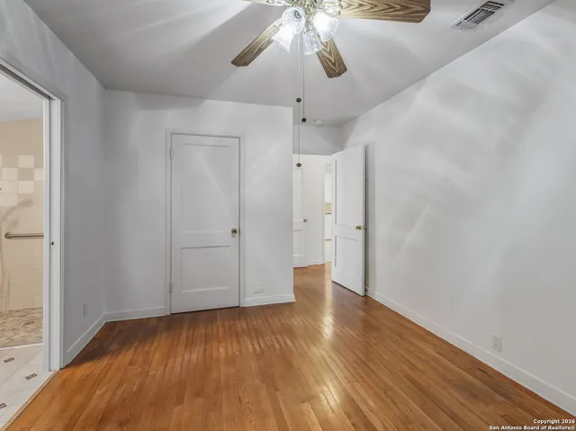 a view of an empty room with wooden floor