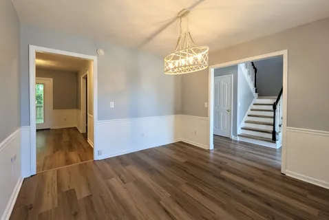 an empty room with wooden floor and a ceiling fan