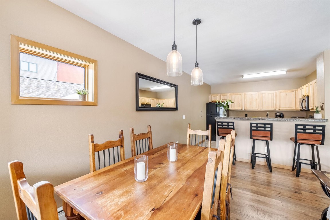 23110 Highway 6, Unit 5015 Keystone, CO 80435 - Photo 11 of 32 a dining room with wooden floor a chandelier a wooden table and chairs