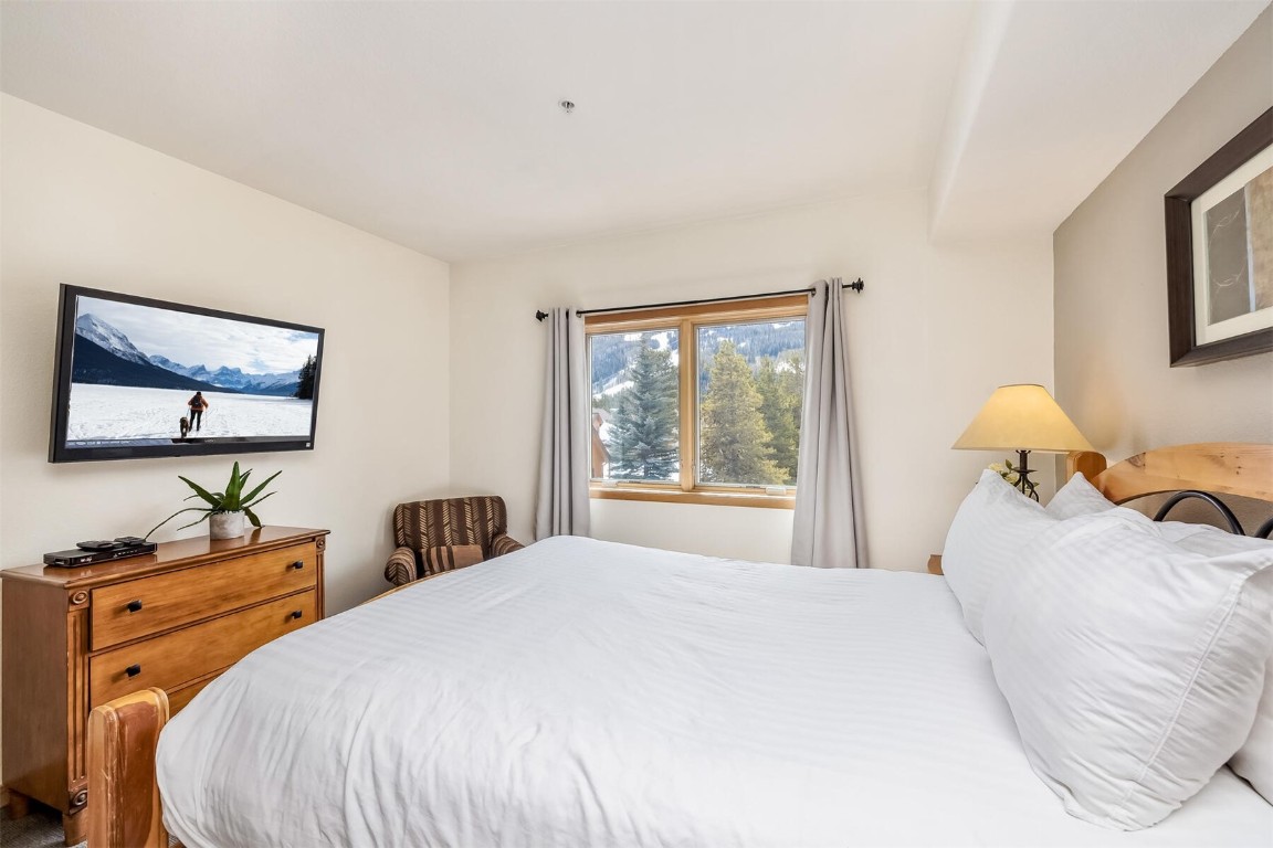 23110 Highway 6, Unit 5015 Keystone, CO 80435 - Photo 18 of 32 a bedroom with a bed and a flat screen tv