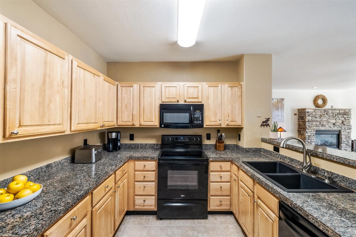 23110 Highway 6, Unit 5015 Keystone, CO 80435 - Photo 8 of 32 a kitchen with granite countertop a sink a counter top space appliances and cabinets