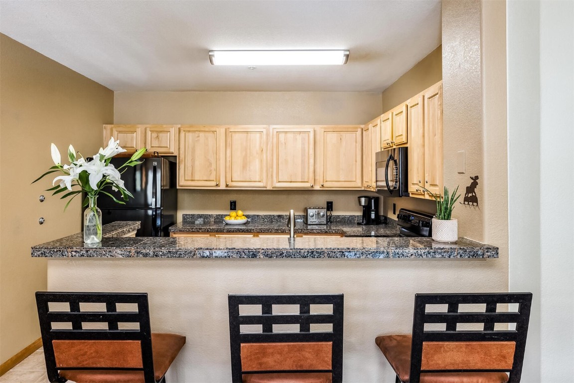 23110 Highway 6, Unit 5015 Keystone, CO 80435 - Photo 10 of 32 a kitchen with stainless steel appliances granite countertop a sink stove and cabinets