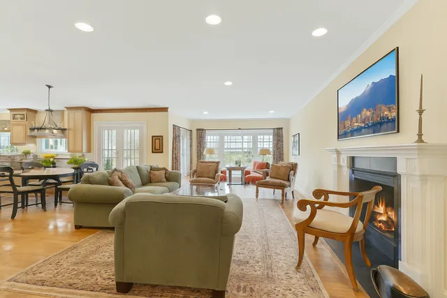 a living room with furniture a fireplace and a floor to ceiling window