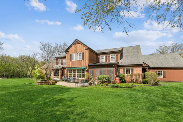 a view of a big house with a big yard and large trees