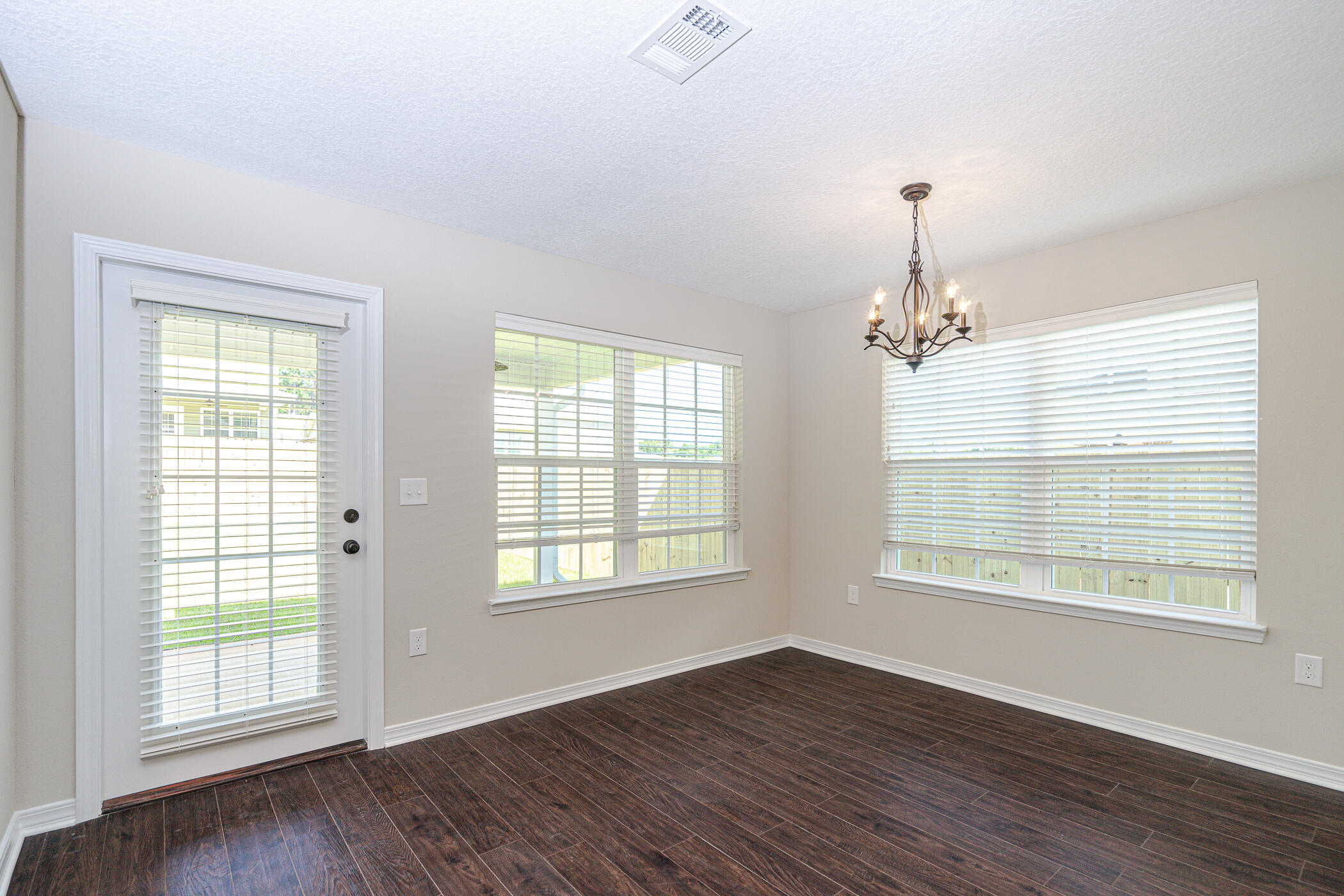 243 Wainwright Drive Crestview, FL 32539 - Photo 13 of 38 a view of an empty room with wooden floor and a window