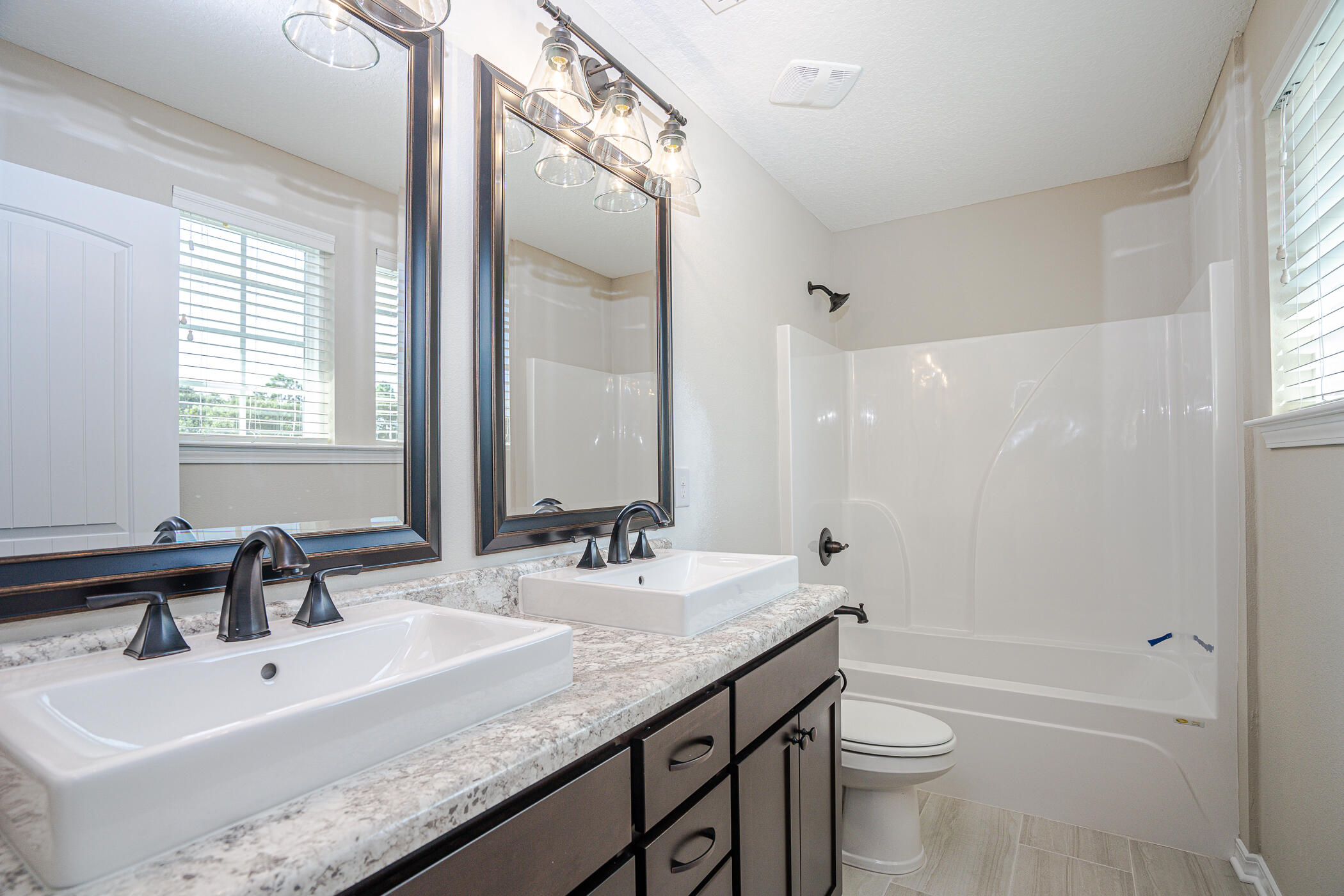 243 Wainwright Drive Crestview, FL 32539 - Photo 35 of 38 a bathroom with a granite countertop sink a toilet and shower