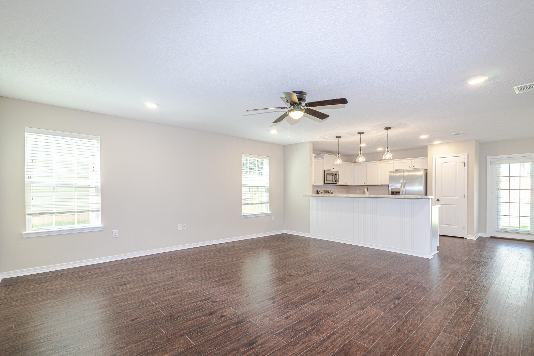 243 Wainwright Drive Crestview, FL 32539 - Photo 7 of 38 a view of an empty room with wooden floor and a window