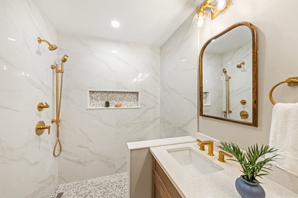 110 Wilson Road Bedford, MA 01730 - Photo 24 of 37 a bathroom with a sink a mirror and a shower