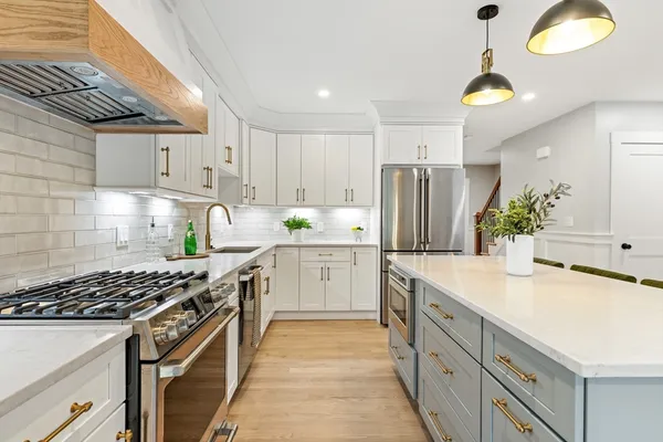 a kitchen with kitchen island granite countertop a sink stove and refrigerator