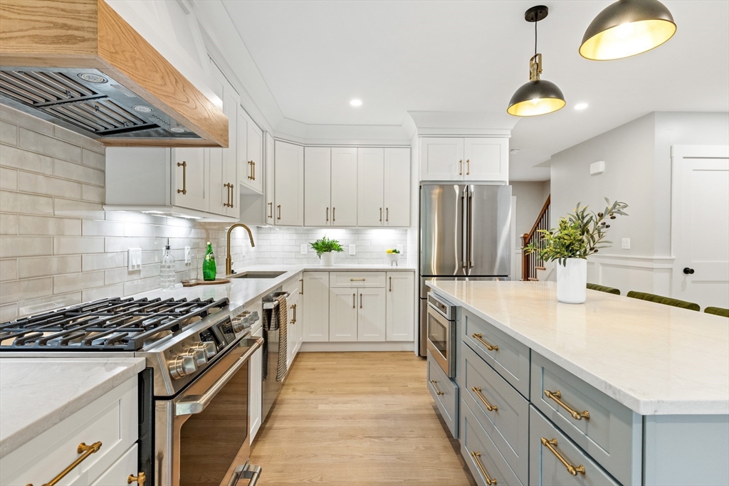 110 Wilson Road Bedford, MA 01730 - Photo 10 of 37 a kitchen with kitchen island granite countertop a sink stove and refrigerator