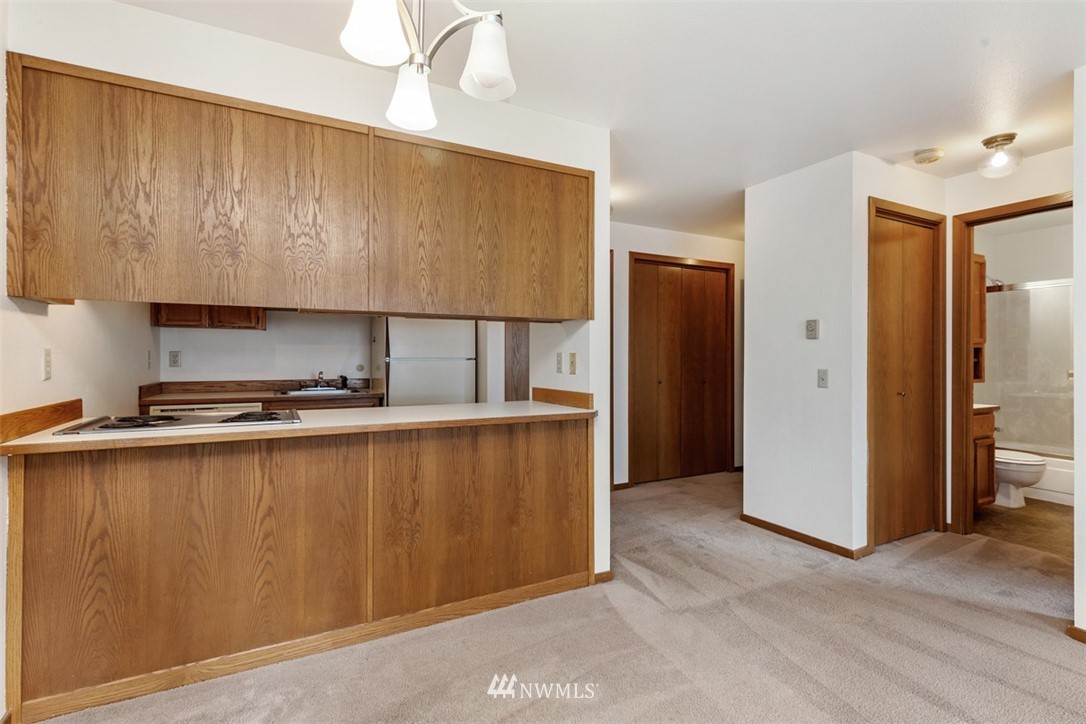 1300 North 107th Street Seattle, WA 98133 - Photo 12 of 20 a kitchen with stainless steel appliances granite countertop a refrigerator a sink and a stove