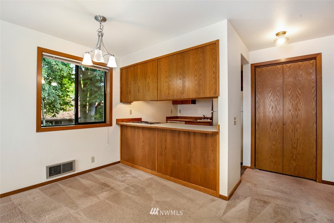 1300 North 107th Street Seattle, WA 98133 - Photo 13 of 20 a kitchen that has a lot of cabinets and a wooden floor