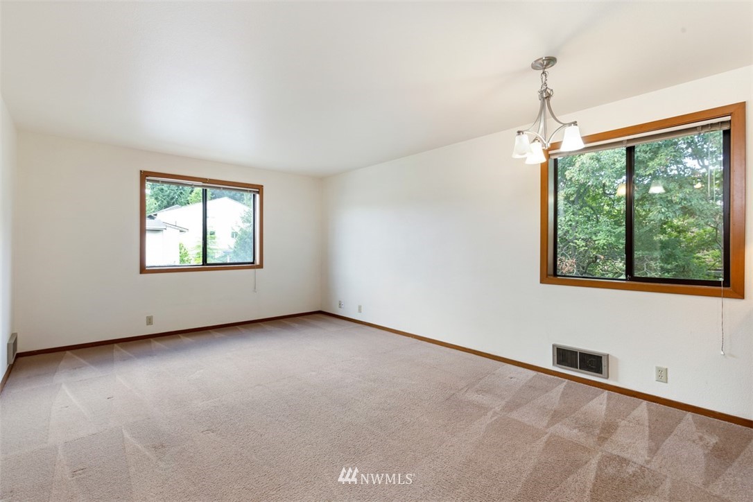 1300 North 107th Street Seattle, WA 98133 - Photo 9 of 20 an empty room with windows and ceiling fan