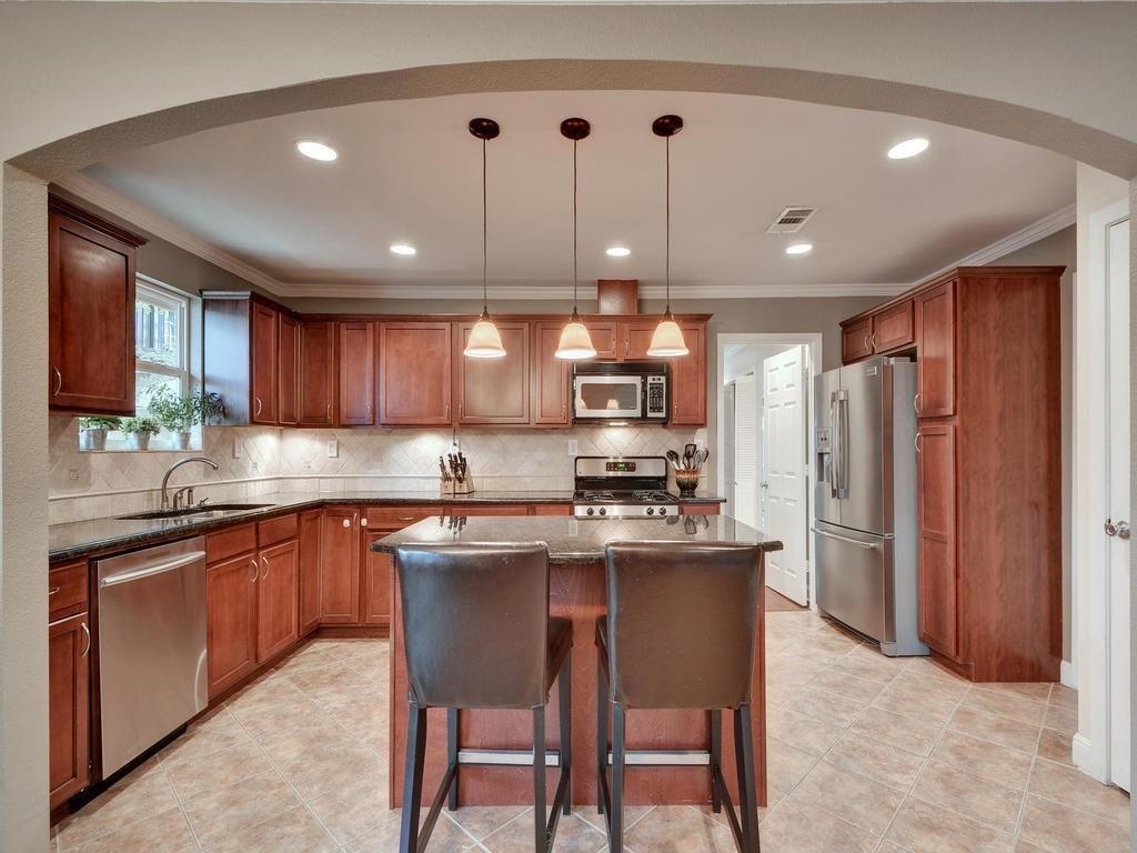 610 West N Loop Boulevard Austin, TX 78751 - Photo 3 of 29 The kitchen features dark wood cabinetry, granite countertops, and stainless steel appliances