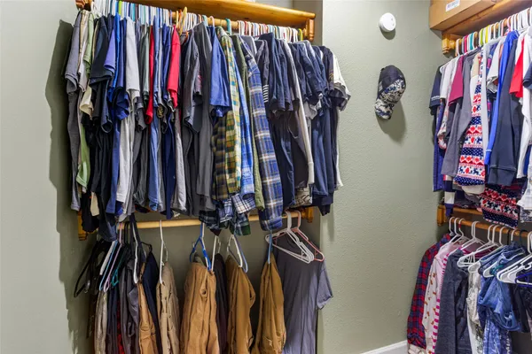 a view of walk in closet with clothes