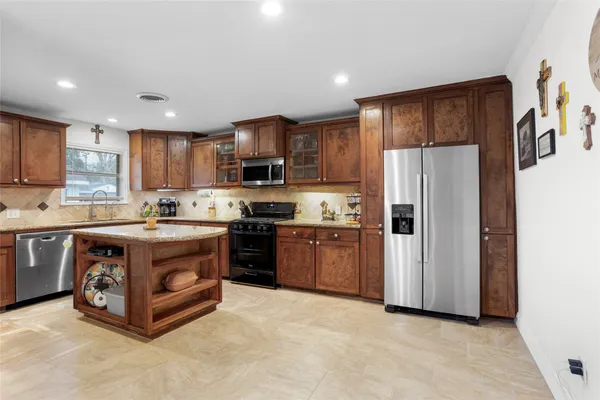 a kitchen with stainless steel appliances granite countertop a refrigerator stove and a sink