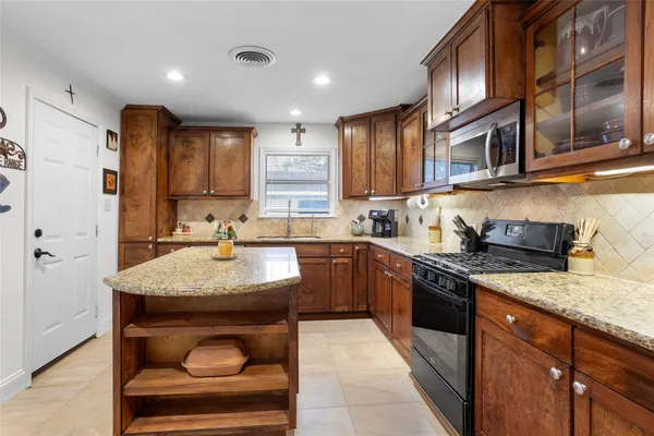 a kitchen with stainless steel appliances granite countertop a sink stove and cabinets