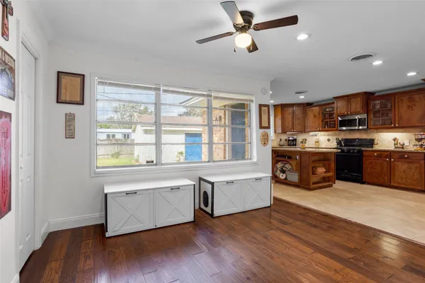 a large kitchen with stainless steel appliances granite countertop a stove a sink dishwasher a refrigerator and a large window