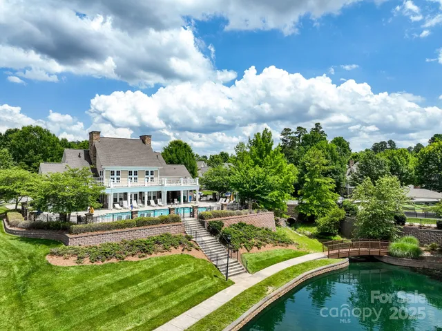 an aerial view of a house with swimming pool a yard and lake view