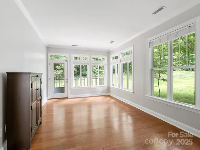 a view of a big room with wooden floor and windows