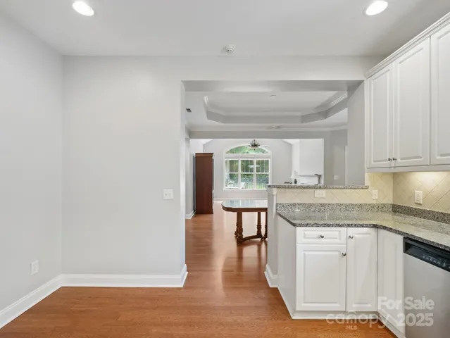 a kitchen with granite countertop a sink cabinets and wooden floor