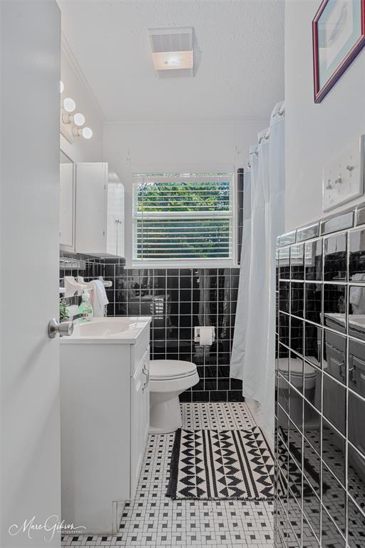 9342 Dean Road Shreveport, LA 71118 - Photo 12 of 18 Bathroom featuring a white vanity with integrated sink, black subway tile walls, and a white mosaic tile floor