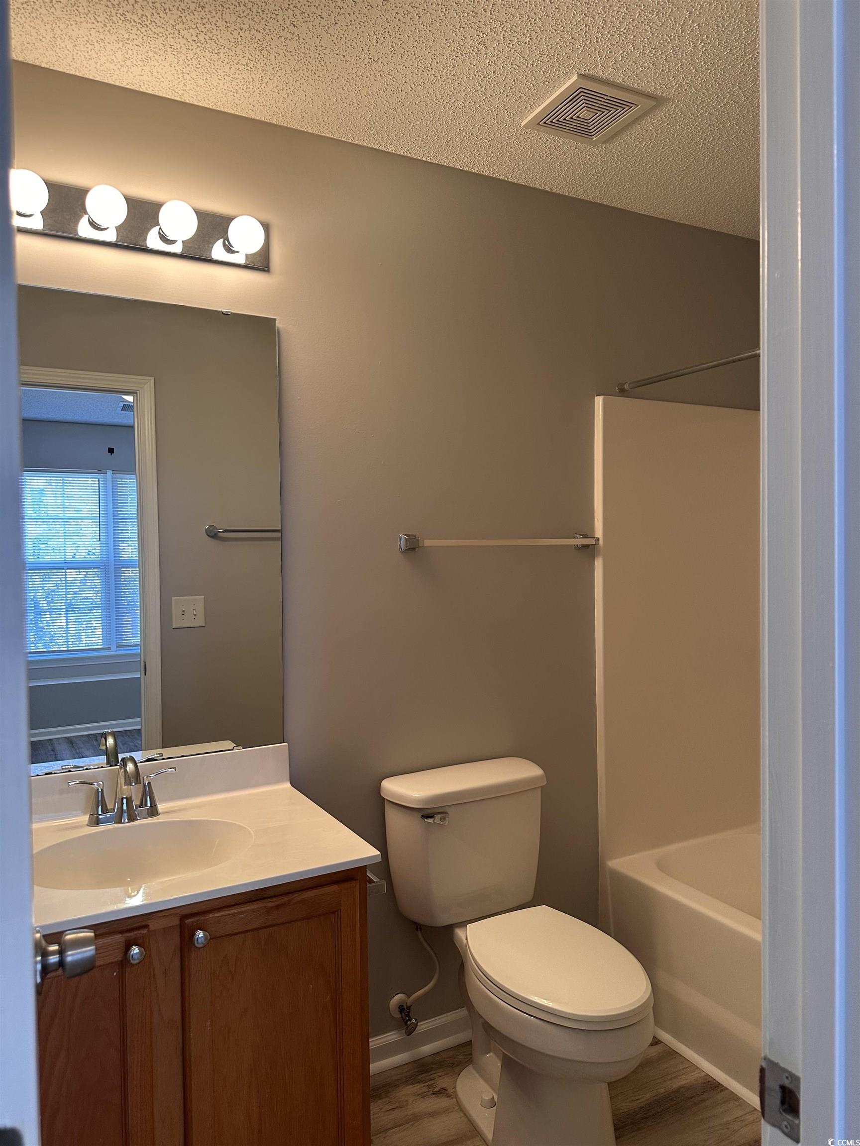 257 Seabert Road Myrtle Beach, SC 29579 - Photo 13 of 16 Bathroom featuring vanity, a textured ceiling, and bathing tub / shower combination