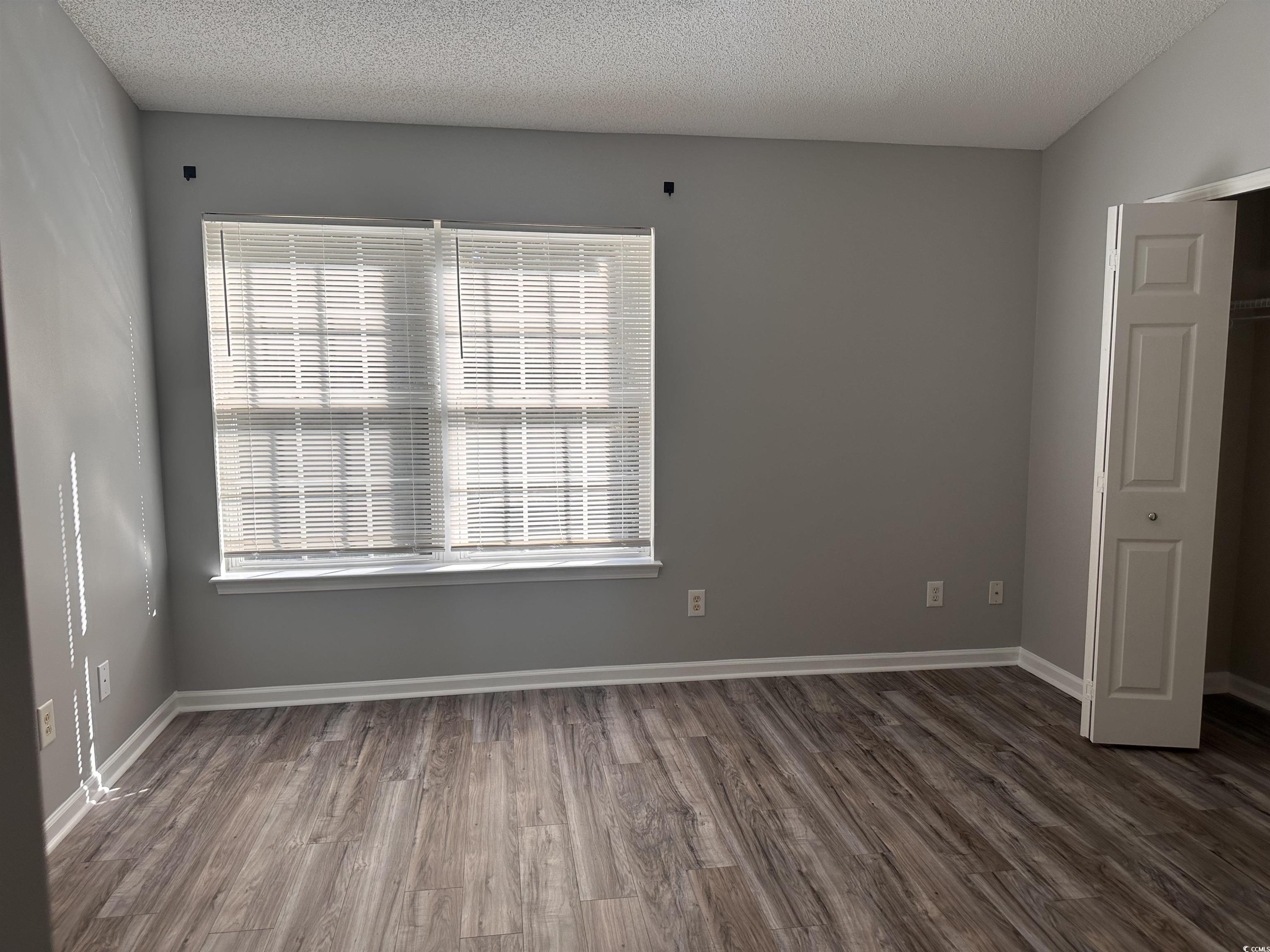257 Seabert Road Myrtle Beach, SC 29579 - Photo 10 of 16 Empty room featuring dark wood-style flooring and a textured ceiling