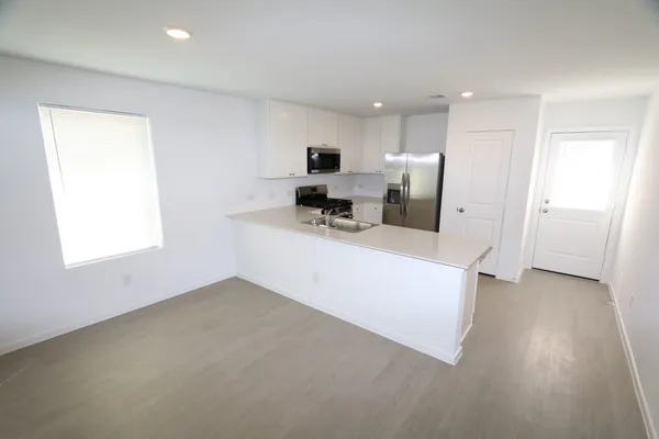 a view of a kitchen with furniture and wooden floor