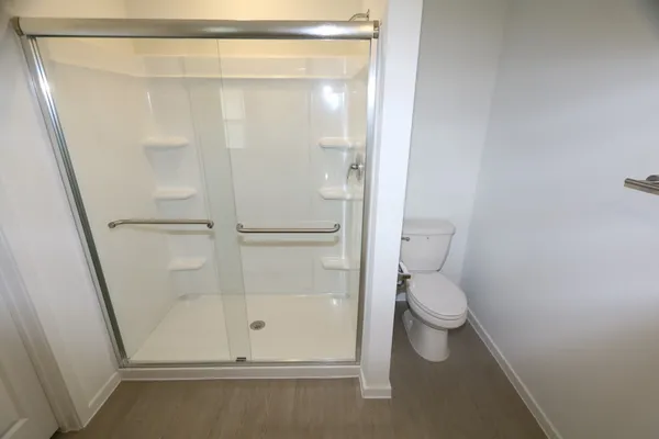 a white toilet sitting next to a shower