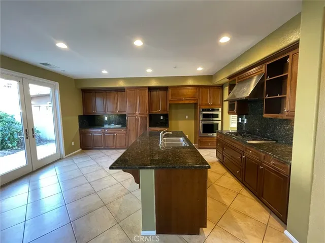 a kitchen with stainless steel appliances granite countertop a sink and a refrigerator