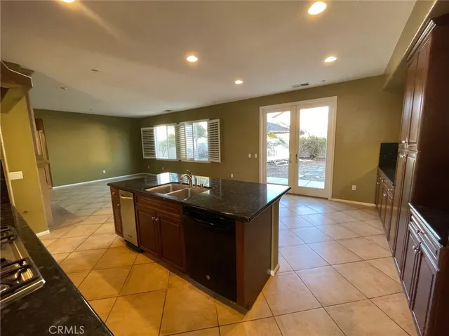 a kitchen with granite countertop a sink and a stove
