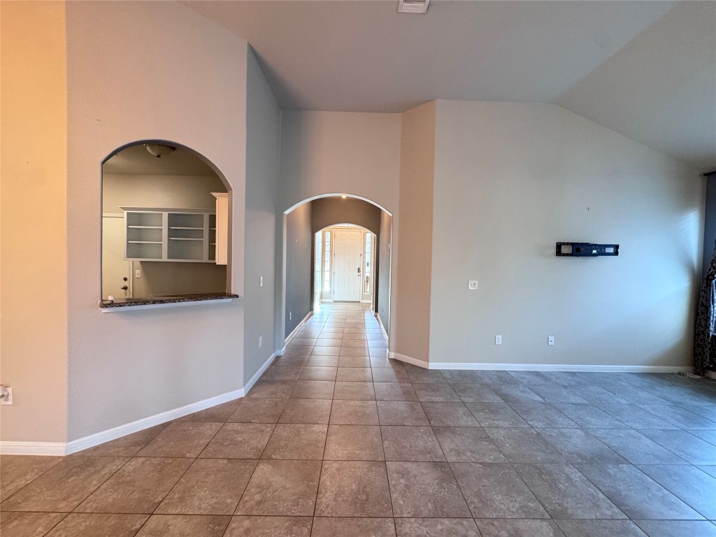 16420 Pienza Drive Pflugerville, TX 78660 - Photo 18 of 26 Tiled empty room with arched walkways and vaulted ceiling