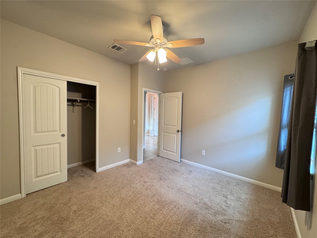 16420 Pienza Drive Pflugerville, TX 78660 - Photo 23 of 26 Unfurnished bedroom with ceiling fan, a closet, and light colored carpet