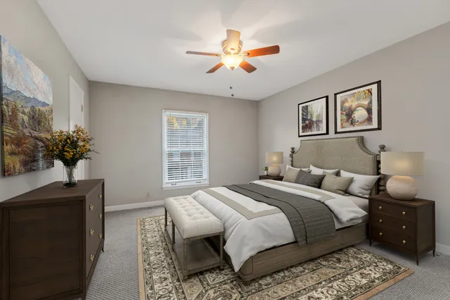 a bedroom with a large bed and a chandelier