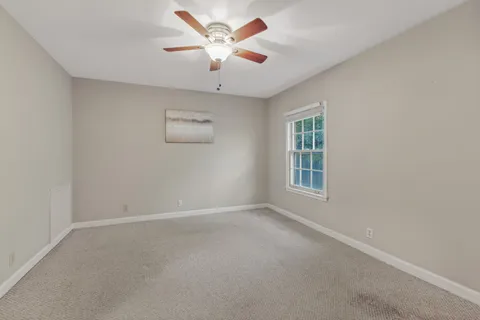 an empty room with a window and a fan