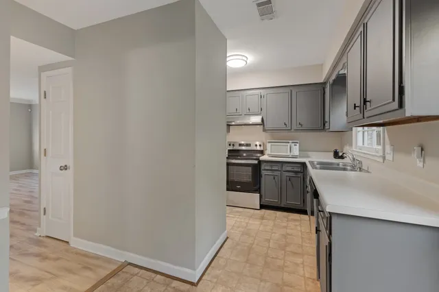 a kitchen with stainless steel appliances a sink stove and refrigerator