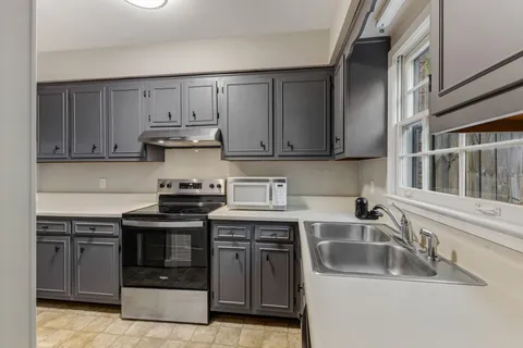 a kitchen with stainless steel appliances granite countertop a sink and stove top oven