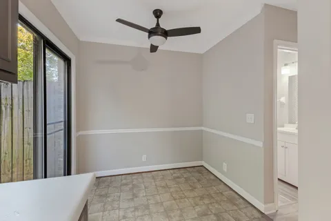 a view of a hallway with a window and a ceiling fan