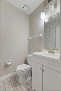 a bathroom with a toilet a sink and mirror