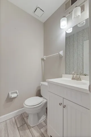 a bathroom with a toilet a sink and mirror