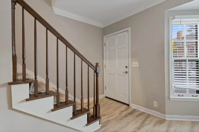 a view of a hallway with wooden floor and staircase