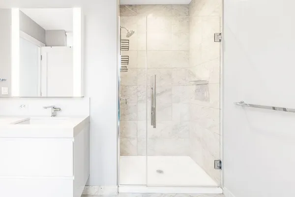 a bathroom with a shower a mirror and a sink