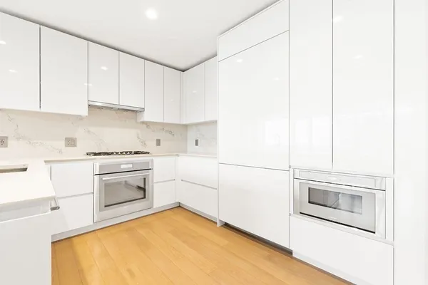a kitchen with granite countertop white cabinets and white appliances