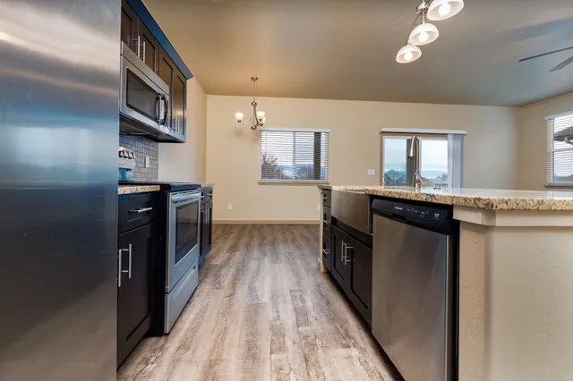 a kitchen with granite countertop a sink stove and refrigerator