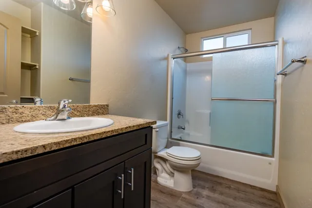 a bathroom with a granite countertop sink toilet and shower