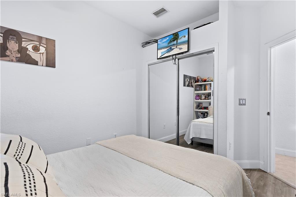 7542 Bristol Circle Naples, FL 34120 - Photo 13 of 26 Bedroom with hardwood / wood-style flooring and a closet